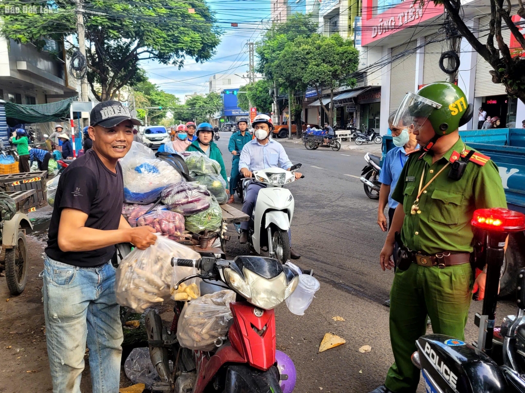 Lực lượng chức năng nhắc nhở người dân buôn bán lấn chiếm lòng đường.