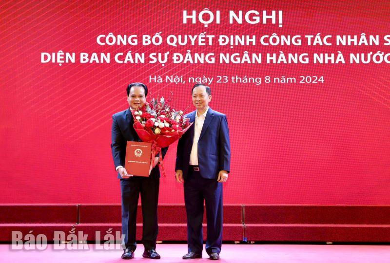 Phó Thống đốc Thường trực NHNN Đào Minh Tú trao Quyết định và tặng hoa chúc mừng tân Phó Tổng Giám đốc Agribank Vương Hồng Lĩnh.