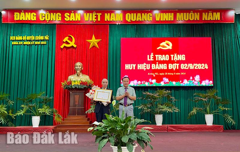 Phó Bí thư Thường trực Huyện ủy Krông Pắc Trần Quốc Vĩnh trao Huy hiệu 70 năm tuổi Đảng cho đảng viên Lê Viết Khóa (Đảng bộ xã Ea Kênh)