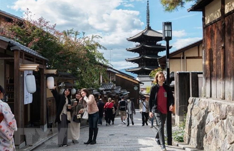 Du khách chụp ảnh trên con đường lát đá dành cho người đi bộ ở Kyoto, Nhật Bản. Ảnh minh họa: AFP/TTXVN