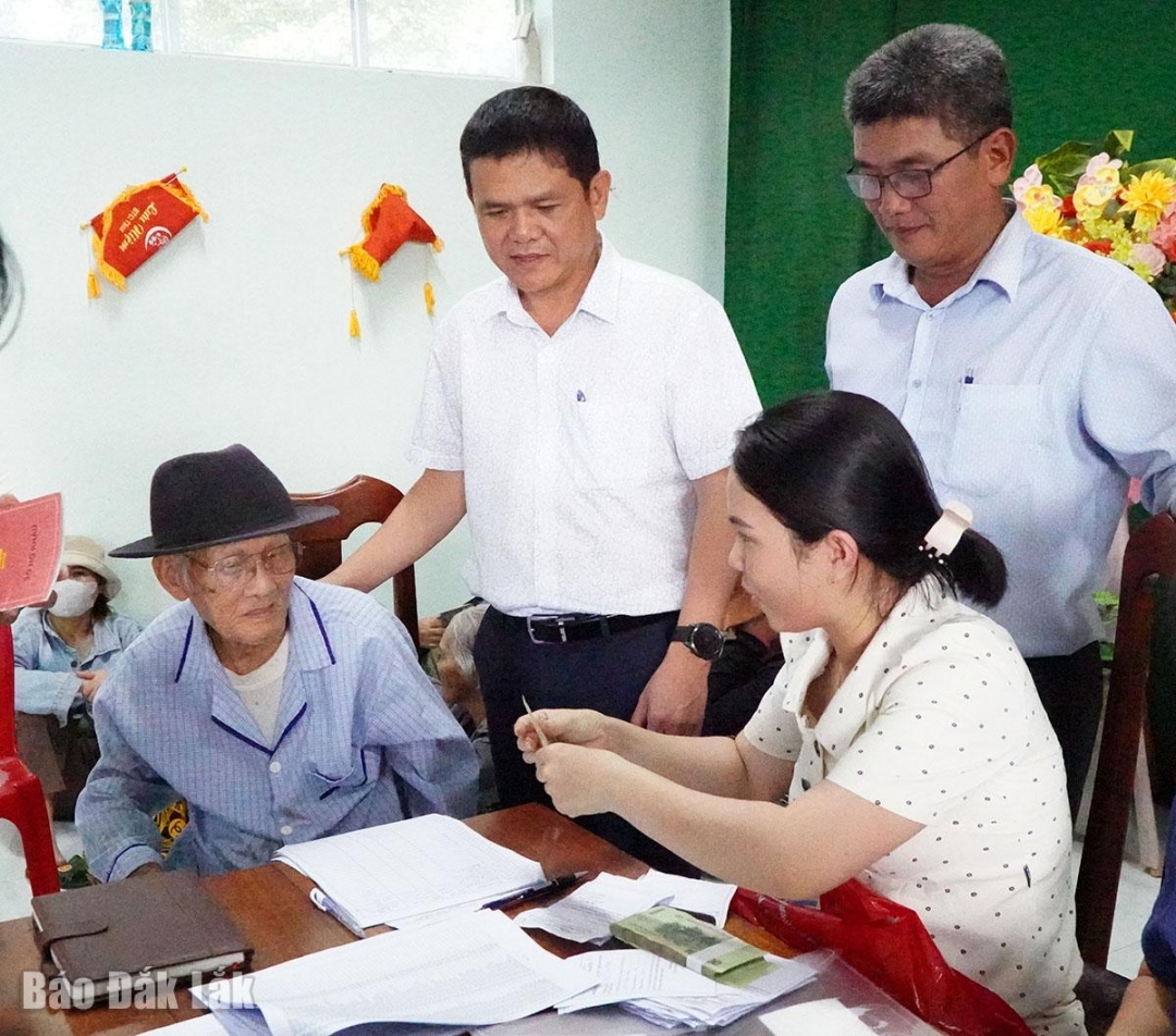 Ông Huỳnh Mỹ Phong Chủ tịch UBND phường Đông Hòa (người đứng bên trái) tới khu phố Nam Bình 1 kiểm tra công tác phát nhận quà cho người dân.