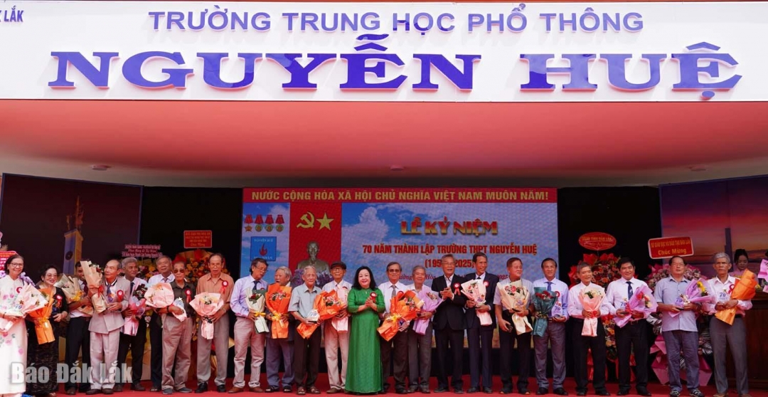 Đồng chí Cao Thị Hòa An tặng hoa và kỷ niệm chương cho các cựu giáo viên của trường.