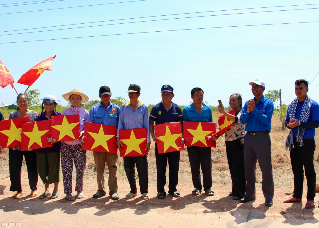 Đại diện các đơn vị tặng cờ Tổ quốc cho người dân xã biên giới Ia Lốp.