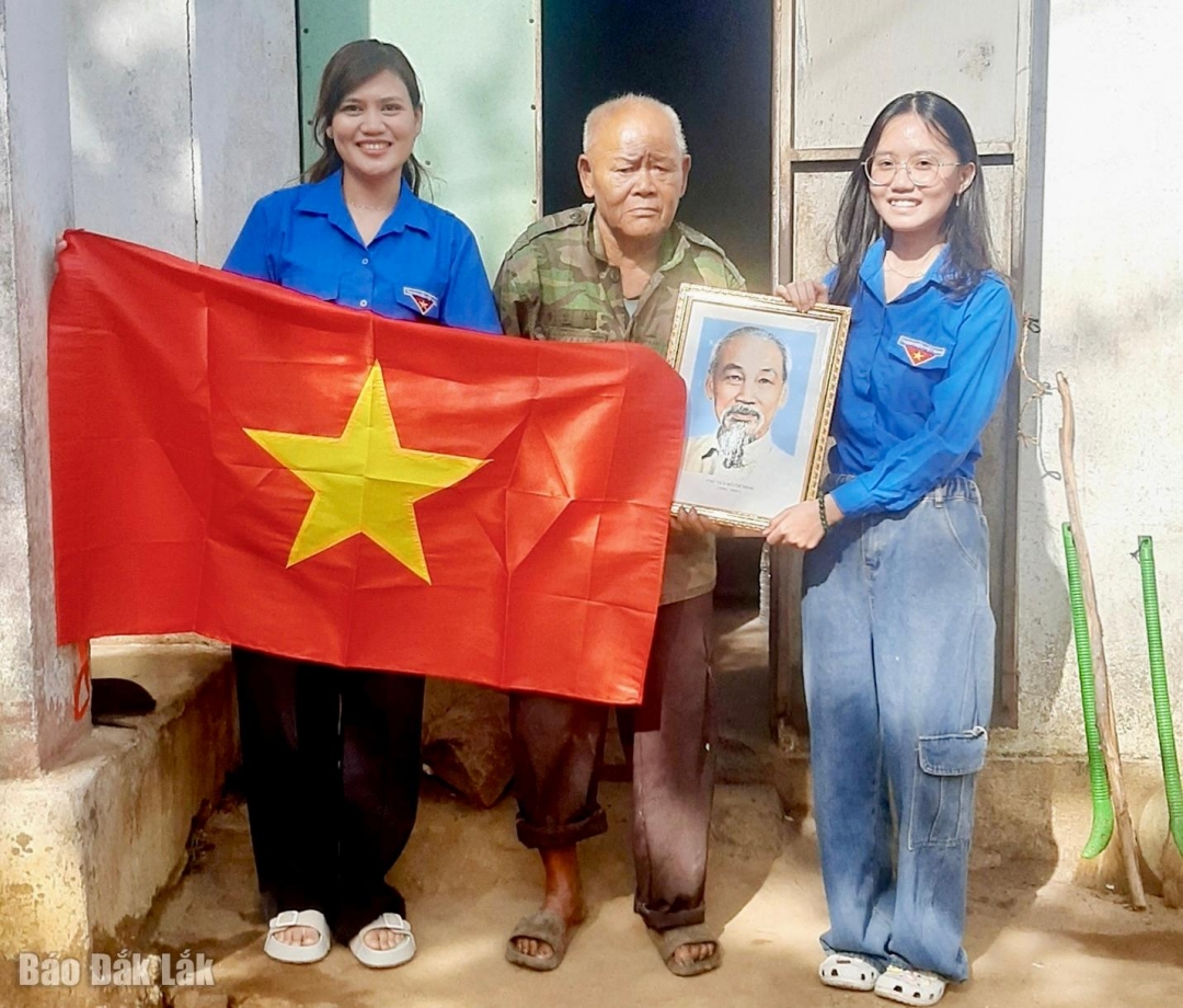 Đoàn viên thanh niên xã Vân Hoà trao tặng cờ Tổ quốc và ảnh Bác Hồ cho các gia đình chính sách trên địa bàn.