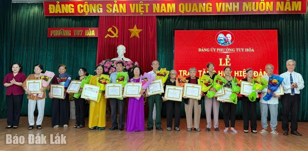 Bí thư Đảng ủy phường Tuy Hòa Đào Bảo Minh (bên trái) và Phó bí thư thường trực Đảng ủy phường Huỳnh Ngọc Oánh trao huy hiệu đảng cho các đảng viên.