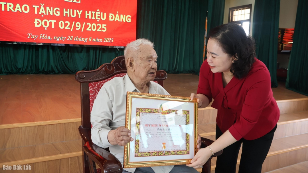 Đảng viên 75 tuổi đảng Trần Văn Thu nhận huy hiệu đảng.