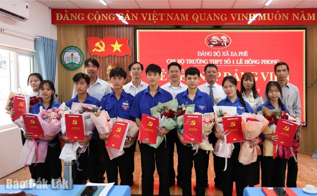 Lãnh đạo Đảng ủy xã Ea Phê và Chi bộ Trường THPT số 1 Lê Hồng Phong tặng hoa chúc mừng các đảng viên mới.