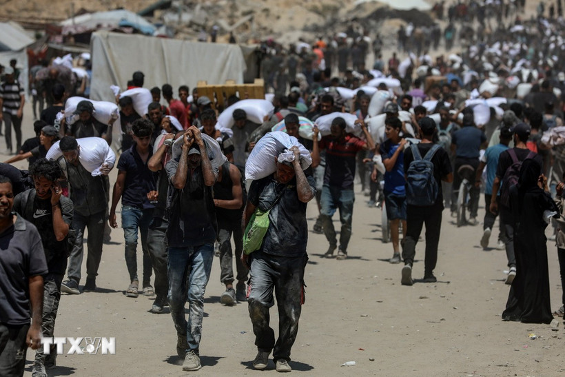 Người dân Palestine nhận hàng viện trợ nhân đạo tại Beit Lahia, phía Bắc Dải Gaza, ngày 1/8/2025. Ảnh: TTXVN