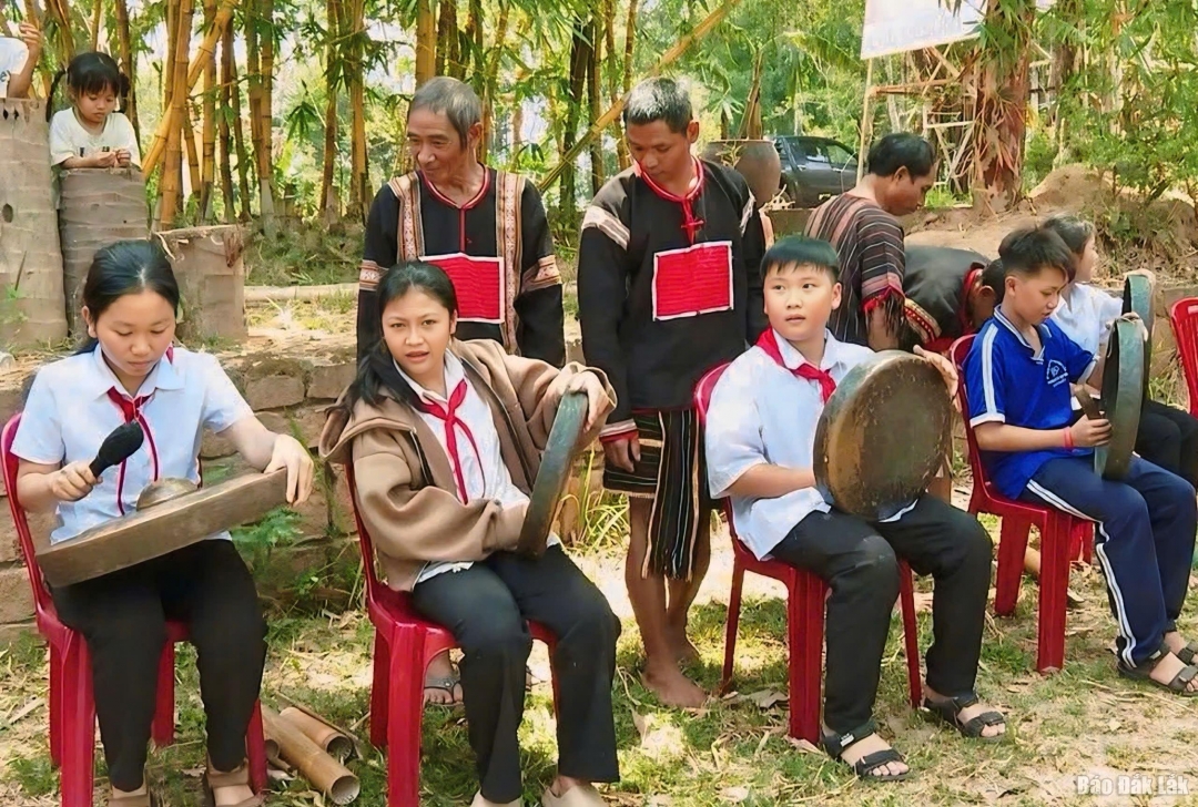 Học sinh Trường THCS Lê Quý Đôn (xã Đắk Liêng) hào hứng trải nghiệm đánh cồng chiêng dưới sự hướng dẫn của nghệ nhân. 