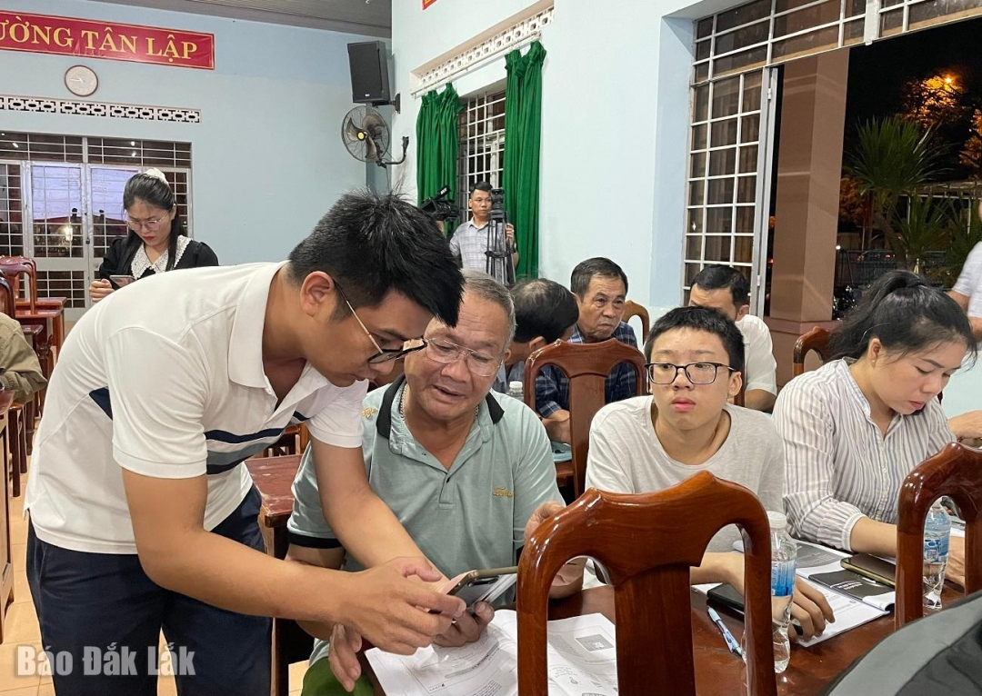 Cán bộ phường Tân Lập hướng dẫn thành viên Tổ công nghệ số cộng đồng thực hành kỹ năng khai thác trên nền tảng số.