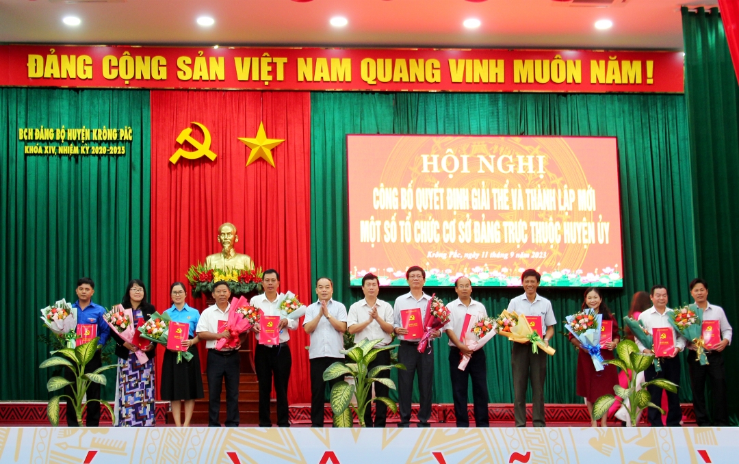 Đại diện các chi bộ mới thành lập nhận hoa và quyết định của Ban Chấp hành Đảng bộ huyện.
