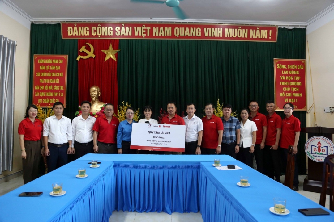 Giám đốc Chi nhánh Vietlott, chi nhánh Khánh Hòa Nguyễn Duy Hiền, thành viên Quỹ Tâm Tài Việt (thứ 8, bên phải) trao tượng trưng thiết bị, dụng cụ học tập cho Trường THPT Ỷ La. Ảnh: Đ. Minh