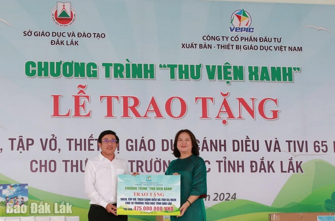 Phó Giám đốc Sở GD-ĐT Lê Thị Kim Oanh nhận bảng tượng trưng Thư viện xanh của Công ty cổ phần Đầu tư Xuất bản - Thiết bị giáo dục Việt Nam.