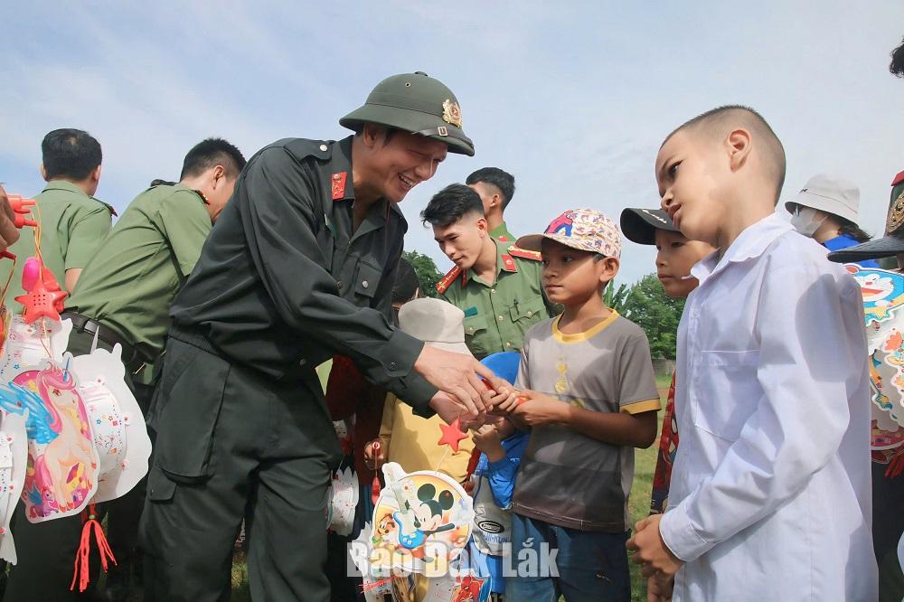 Lãnh đạo Công an huyện Cư Kuin trao quà chho các em thiếu nhi.