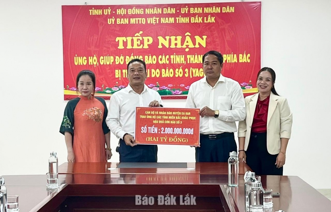 Bí thư Huyện ủy Ea Kar Y Nhuân Byă (thứ hai từ bên phải sang) trao số tiền ủng hộ Quỹ Cứu trợ tỉnh.