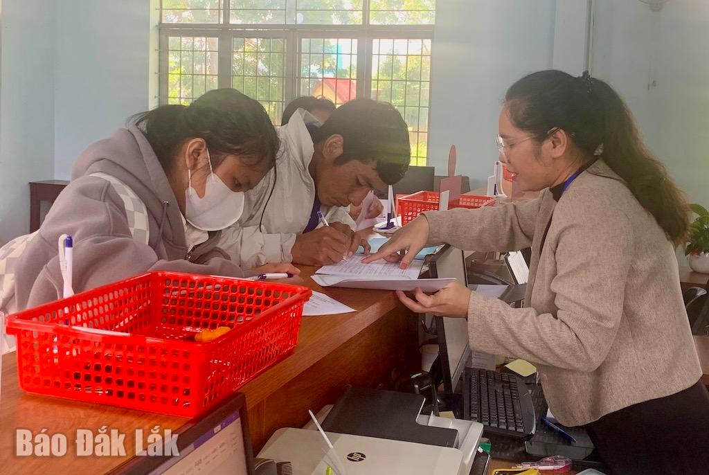Chuyên viên Trung tâm phục vụ hành chính công xã Cuôr Đăng hướng dẫn người dân thực hiện các thủ tục hành chính