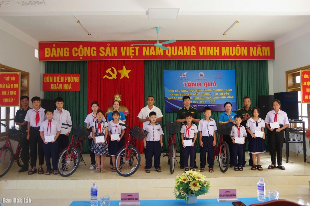 Đại diện Đồn Biên phòng Xuân Hòa phối hợp với Ủy ban MTTQ Việt Nam xã Xuân Cảnh trao quà cho các em học sinh. 