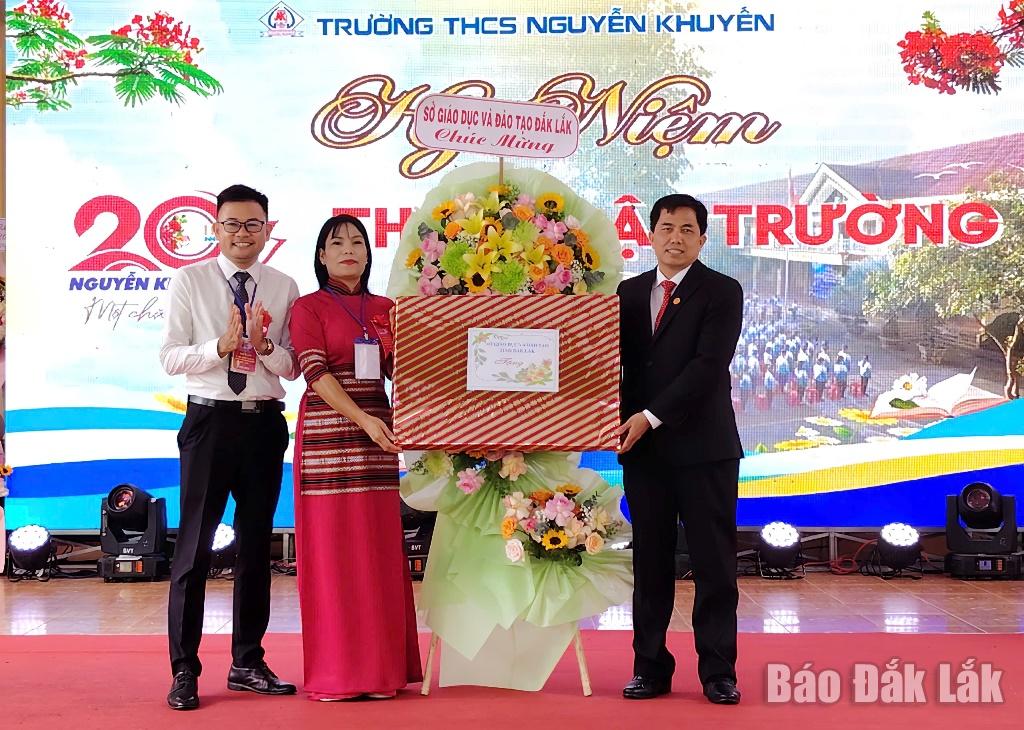 Phó Giám đốc Sở Giáo dục - Đào tạo Nguyễn Xuân Đá tặng hoa và quà chúc mừng Trường THCS Nguyễn Khuyến.