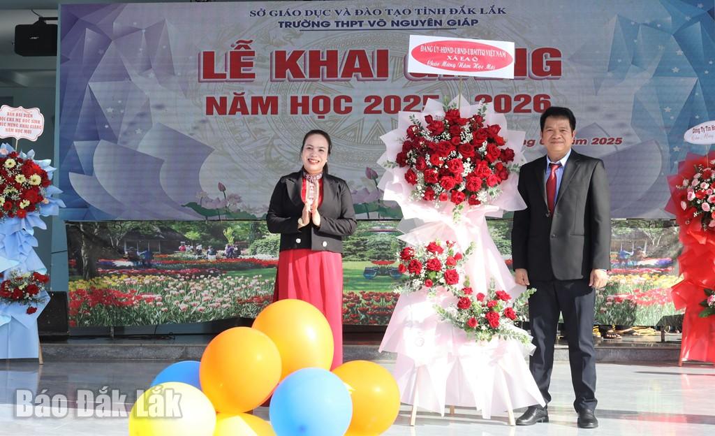 Bí thư Đảng ủy xã Ea Ô H Nan Byă tặng hoa chúc mừng Trường THPT Võ Nguyên Giáp.