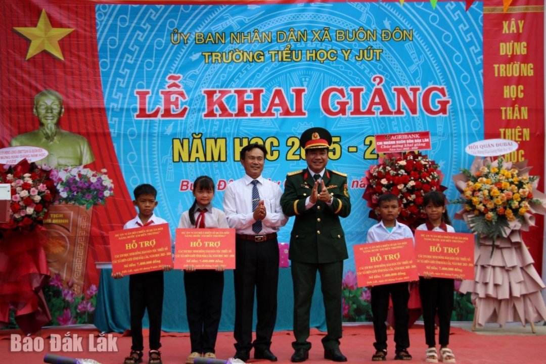 Đại tá Ksơr Lành, Phó Chính ủy Bộ Chỉ huy Quân sự tỉnh và đại diện nhà trường trao bảng tượng trưng cho các học sinh có hoàn cảnh khó khăn.