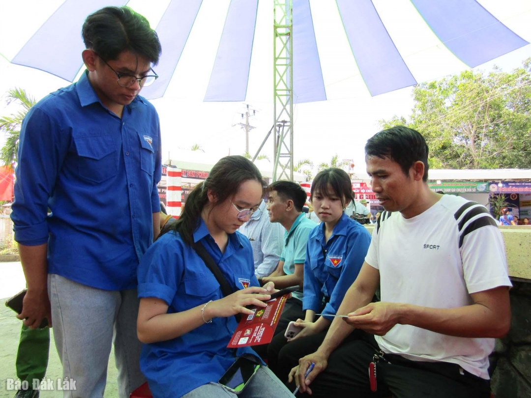 Các bạn đoàn viên thanh niên hướng dẫn người dân cài đặt, sử dụng ứng dụng số trên điện thoại.