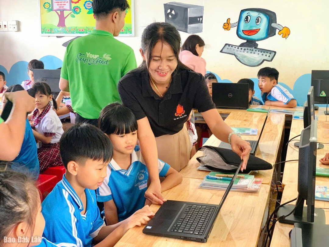 Giáo viên hướng dẫn học sinh thực hành trên máy vi tính mới.