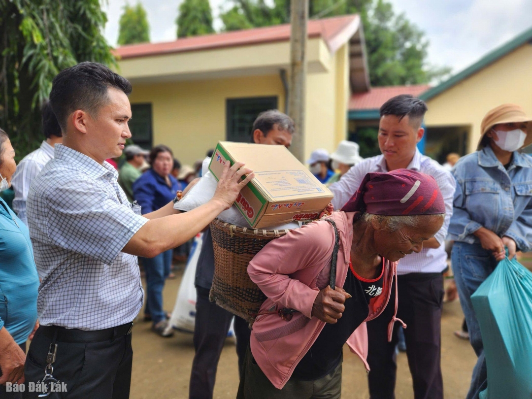 Lãnh đạo xã Ea Na trao quà cho người dân trên địa bàn.
