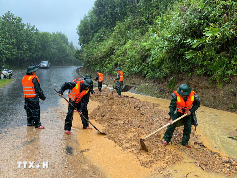 Bộ đội biên phòng thành phố Huế đào xúc đất đá, san gạt mặt đường bị sạt lở đất tại đèo Pê Kê, xã A Lưới 1. Ảnh: TTXVN