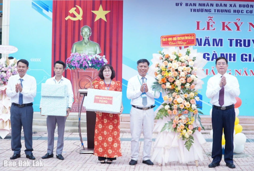Ủy viên Ban Chấp hành Trung ương Đảng, Bí thư Tỉnh ủy Nguyễn Đình Trung tặng hoa và quà chúc mừng giáo viên và học sinh Trường THCS Võ Thị Sáu (xã Buôn Đôn). Ảnh: Như Quỳnh
