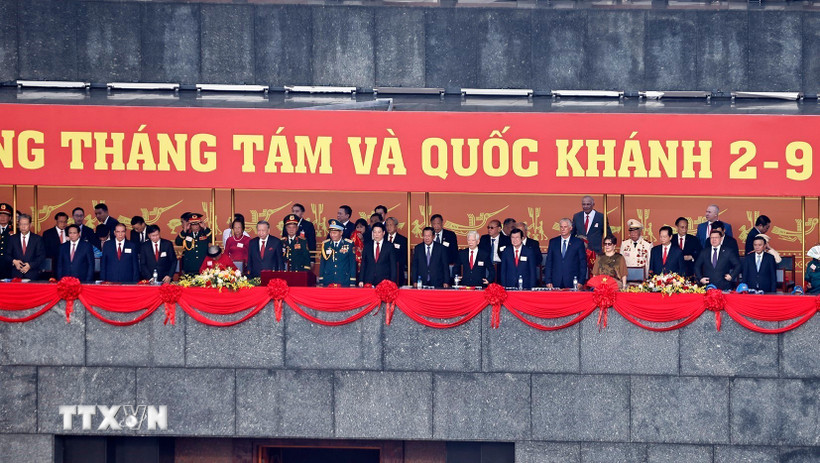 Các đồng chí lãnh đạo, nguyên lãnh đạo Đảng, Nhà nước, các vị khách quốc tế và các đại biểu thực hiện nghi lễ chào cờ. Ảnh: TTXVN