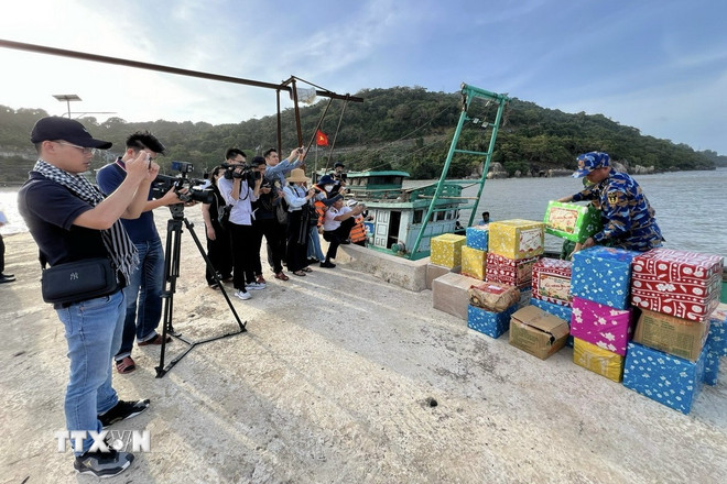 Phóng viên tác nghiệp trong chuyến công tác thăm, chúc tết cán bộ, chiến sỹ nhân dân và các lực lượng trên vùng biển Tây Nam. (Ảnh: TTXVN phát)