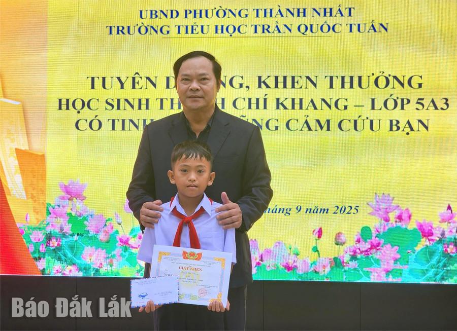 Ông Trần Xuân Kỳ - Hiệu trưởng nhà trường khen thưởng cho em Thạch Chí Khang.