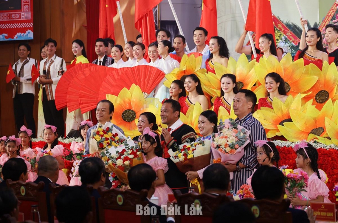 Đồng chí Y Giang Gry Niê Knơng, Ủy viên Ban Thường vụ Tỉnh ủy, Chủ tịch Ủy ban MTTQ Việt Nam tỉnh tặng hoa cho đội văn nghệ. Ảnh: Ngọc Thắng
