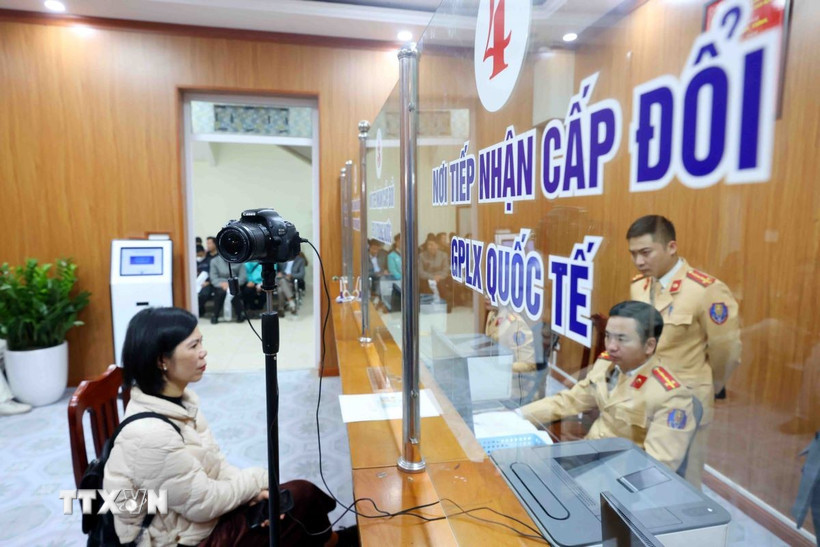 Cán bộ, chiến sỹ Đội Sát hạch, cấp giấy phép lái xe cơ giới đường bộ (Phòng Cảnh sát Giao thông, Công an thành phố Hà Nội) làm thủ tục cấp, đổi giấy phép lái xe cho công dân. Ảnh: TTXVN)