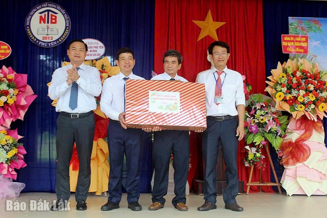 Tỉnh ủy viên, Phó Chủ tịch HĐND tỉnh Đỗ Thái Phong (ngoài cùng bên trái) tặng quà chúc mừng khai giảng năm học mới cho nhà trường.