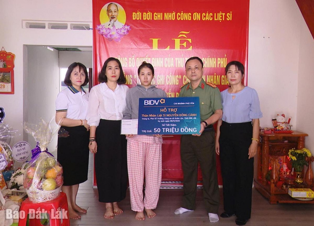 Đại diện các đơn vị trao tiền, sổ tiết kiệm hỗ trợ gia đình liệt sĩ Nguyễn Đông Cánh.