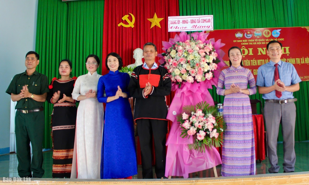 Đại diện lãnh đạo xã Cư M’gar tặng hoa cho Ban tổ chức hội nghị.