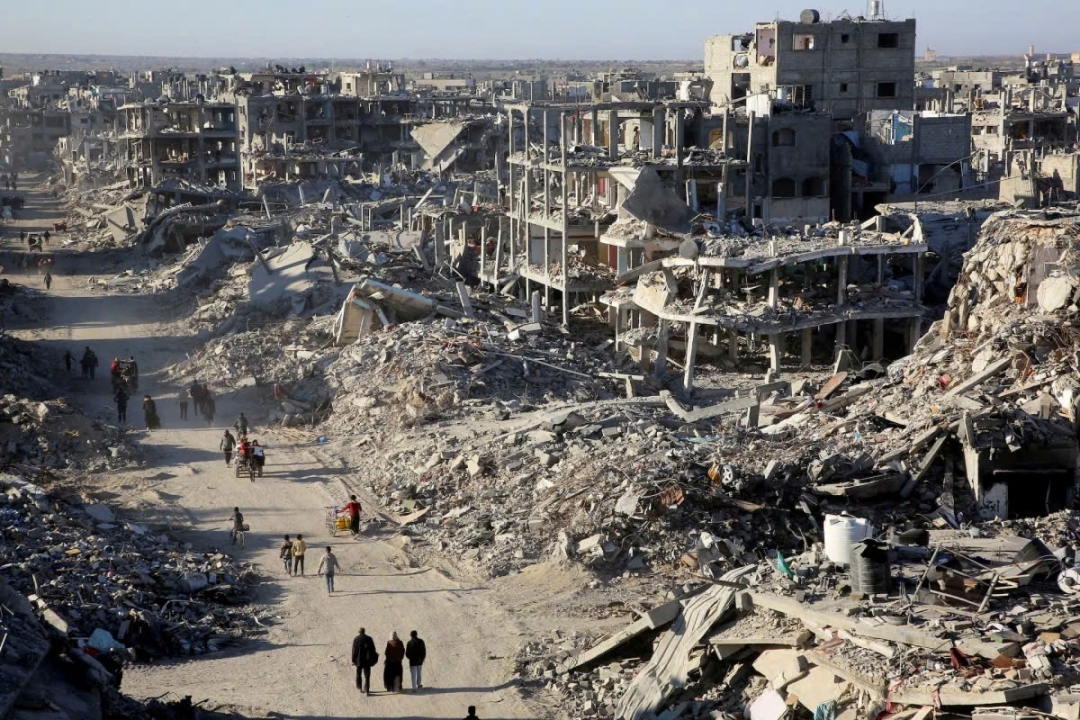 Người dân Palestine đi ngang qua đống đổ nát của những ngôi nhà và tòa nhà bị phá hủy trong chiến tranh, ở Rafah, phía nam Dải Gaza. Ảnh: Reuters