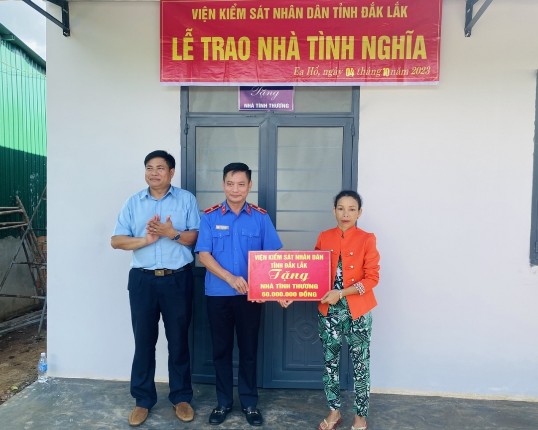 Viện trưởng Viện KSND tỉnh Lê Quang Tiến (đứng giữa) trao biểu trưng căn nhà tặng gia đình chị H’Đak Mlô.