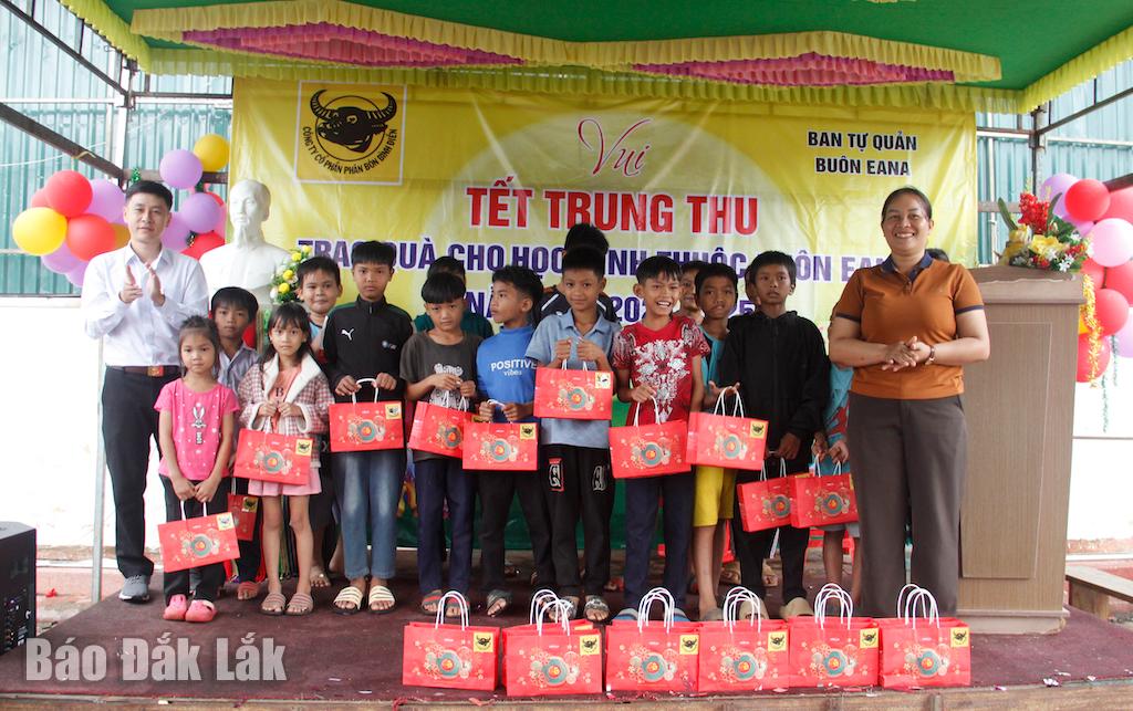 Đại diện Công ty Cổ phần Phân bón Bình điền (bìa trái) và trưởng buôn Ea Na (bìa phải) trao quà Trung thu tặng các em thiếu nhi. 