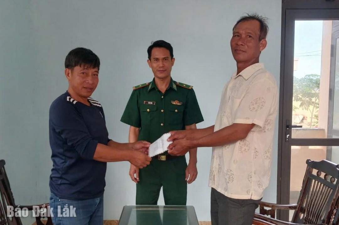 Sau khi được Đồn Biên phòng Hòa Hiệp Nam hòa giải, ông Đào Kim Tri (bên phải) hỗ trợ ông Lê Văn Cường số tiền 9 triệu đồng để khắc phục thiệt hại.