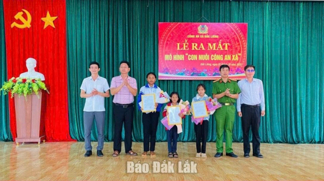 Đại diện lãnh đạo Công an xã Đắk Liêng và chính quyền địa phương tặng hoa, quà cho các cháu được nhận đỡ đầu.
