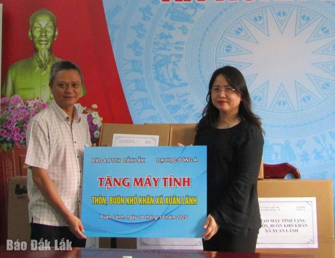 Tổng Biên tập Báo và Phát thanh, Truyền hình Đắk Lắk Đào Phạm Hoàng Quyên trao máy tính cho lãnh đạo xã Xuân Lãnh.