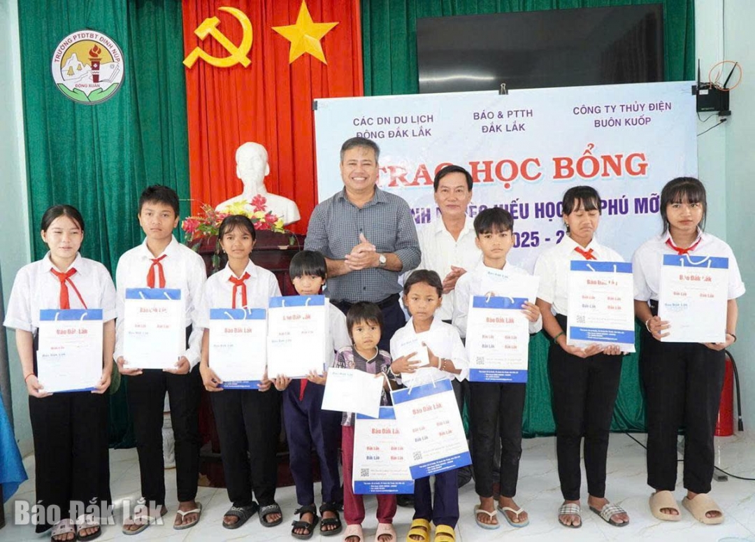 Phó Tổng Biên tập Phạm Khánh Minh trao quà cho học sinh Trường Phổ thông Dân tộc bán trú Đinh Núp.