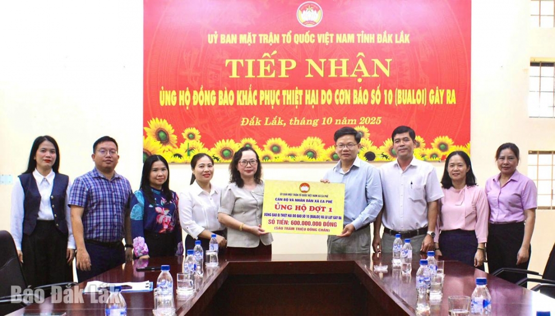 Đoàn công tác của xã Ea Phê trao tiền hỗ trợ đồng bào bị thiệt hại do cơn bão số 10 gây ra.