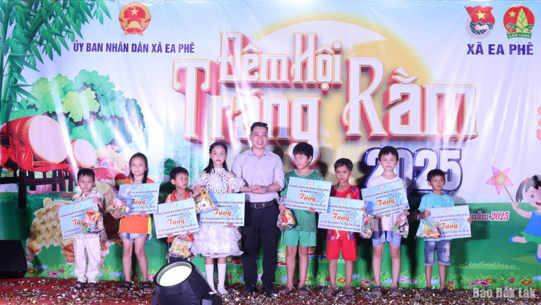 Lãnh đạo xã Ea Phê tặng quà cho các em thiếu niên, nhi đồng.
