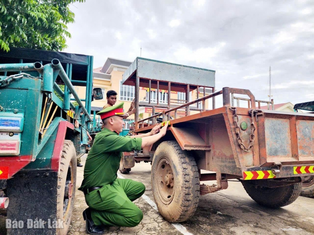 Lực lượng công an xã dán decal phản quang cho xe công nông của người dân trên địa bàn.