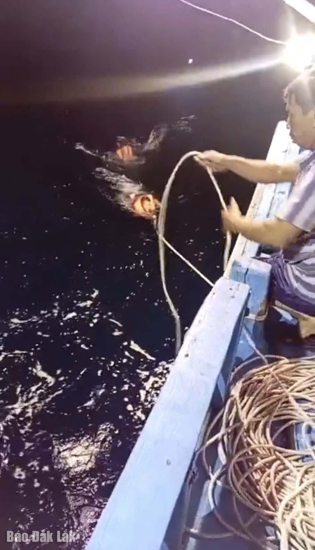 Hai ngư dân bị toong lật thuyền thúng phải đu dây bơi về tàu. Ảnh: ngư dân cung cấp