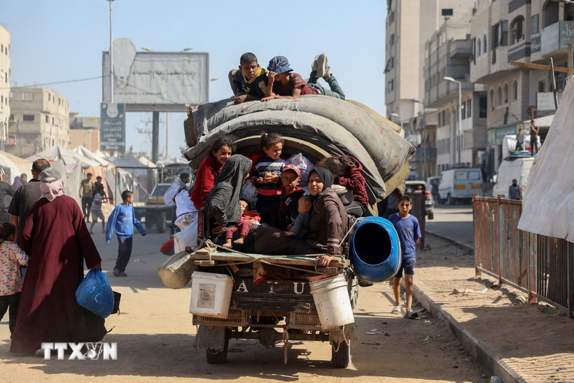 Người dân Palestine mang theo đồ đạc trở về thành phố Gaza ngày 11/10/2025. Ảnh: TTXVN