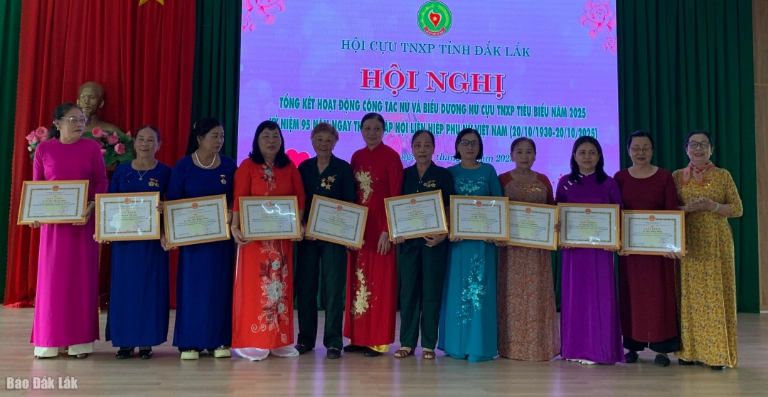 Chủ tịch Hội CựuTNXP Trần Thị Xuân (bìa phải) trao giấy khen cho các nữ cựu TNXP có thành tích xuất sắc trong hoạt động công tác nữ cựu TNXP.